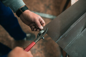 close up of a Worker hands use scissors to cut the metal sheet
